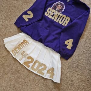 A purple and white outfit with the number 2 4 on it.