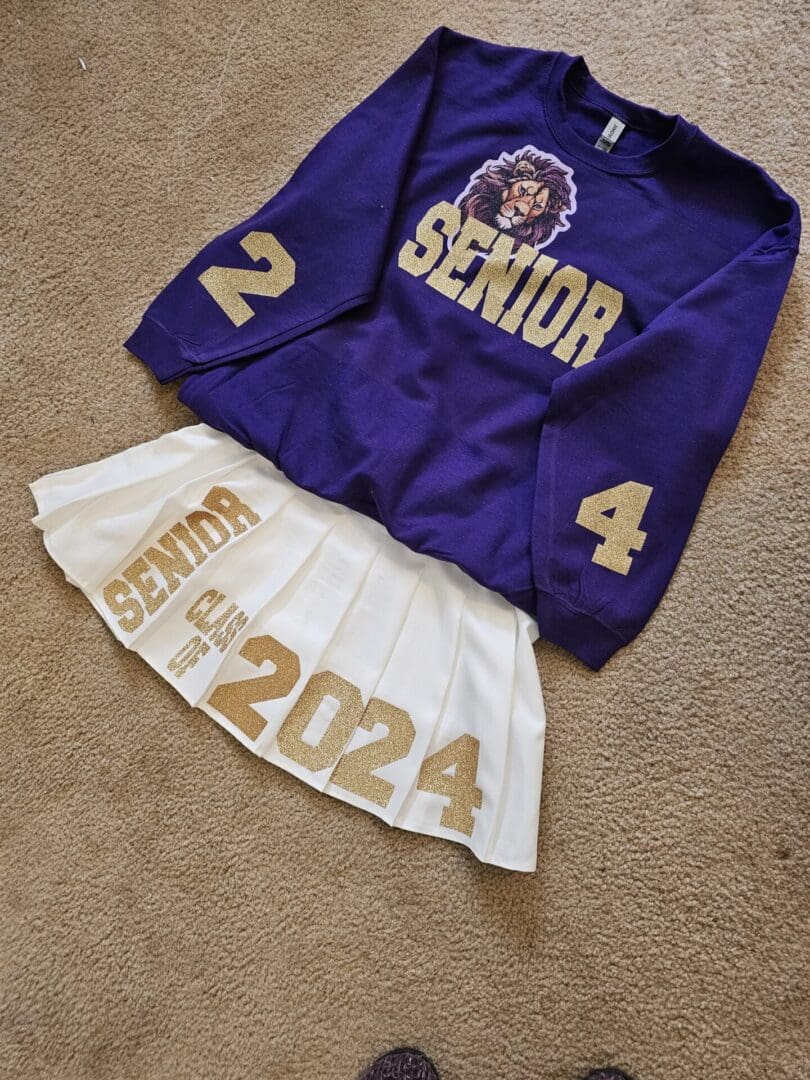 A purple and white outfit with the number 2 4 on it.