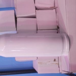 A stack of pink boxes next to a white cylinder.