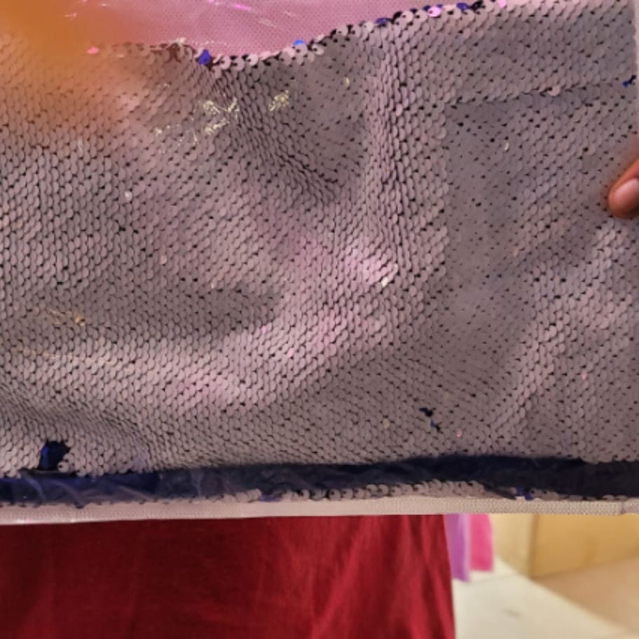 A person holding up a towel with purple stains on it.