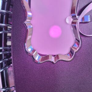 A purple phone case with a pink light on it.