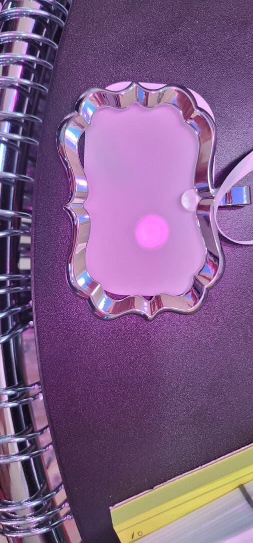 A purple phone case with a pink light on it.