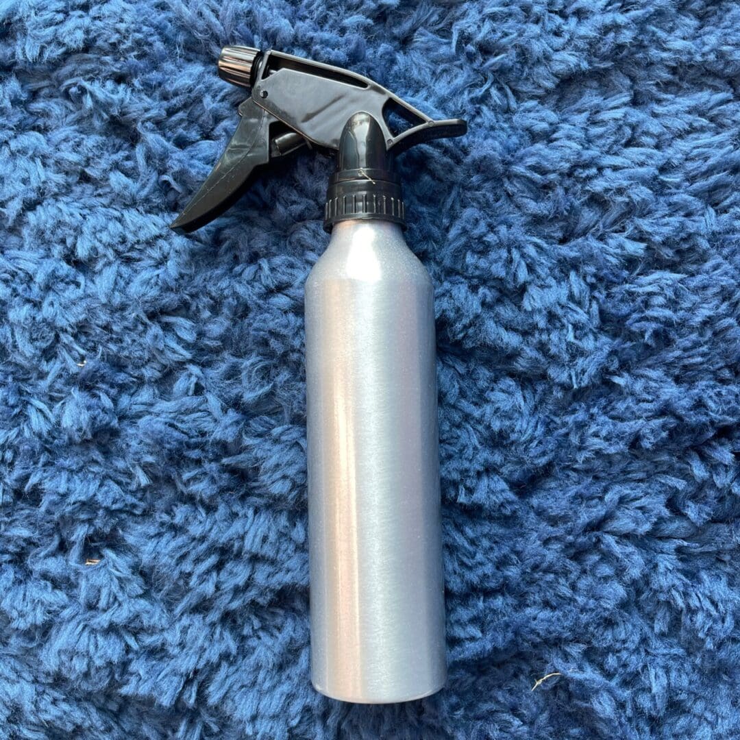 A spray bottle sitting on top of a blue carpet.